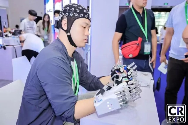 团队成员在2025中国国际福祉博览会暨中国国际康复展览会展示手部康复机器人 学校供图.jpg