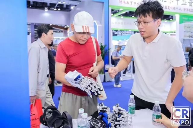 于金须在博览会上向来宾介绍手部康复机器人 学校供图.jpg